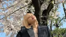Momen Lisa memamerkan senyuman manisnya saat berpose dengan bunga sakura yang sedang mekar. Lisa tampil dengan rambut blondenya yang berponi serta mengenakan blazer yang membuatnya telihat kasual. (Instagram/@lalalalisa_m)