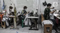 Pekerja menyelesaikan pembuatan baju hazmat di salah satu industri konveksi Pusat Industri Kecil (PIK), Jakarta, Rabu (30/12/2020). Dalam sehari, industri konveksi di PIK mampu memproduksi 50 buah baju hazmat tiap pekerja. (merdeka.com/Iqbal S. Nugroho)