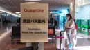 Seorang penumpang berjalan dengan kopernya di aula kedatangan di Bandara Internasional Haneda Tokyo, Jumat (18/2/2022). Pemerintah Jepang mengumumkan rencana untuk melonggarkan aturan perbatasan virus bagi pekerja dan pelajar. (AFP/Philip Fong)