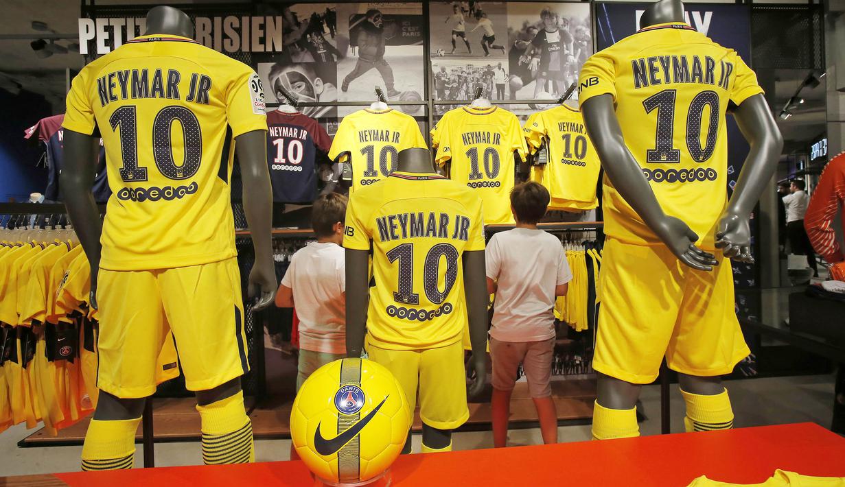Dua orang anak memilih jersey pemain baru Paris Saint Germain, Neymar Jr, di toko merchandise di Paris, Jumat (4/8/2017). Setelah resmi bergabung dengan Paris Saint Germain, jersey Neymar Jr langsung diburu suporter klub Ibu kota. (AP/Michel Euler)