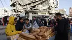 Warga Palestina menjual roti di dekat bangunan yang hancur di pasar Zawiya, Kota Gaza, pada Rabu 18 Februari 2026. Menyambut bulan suci Ramadan 1447 Hijriah, warga Palestina di Kota Gaza memadati Pasar Al-Zawiya. (Omar AL-QATTAA/AFP)