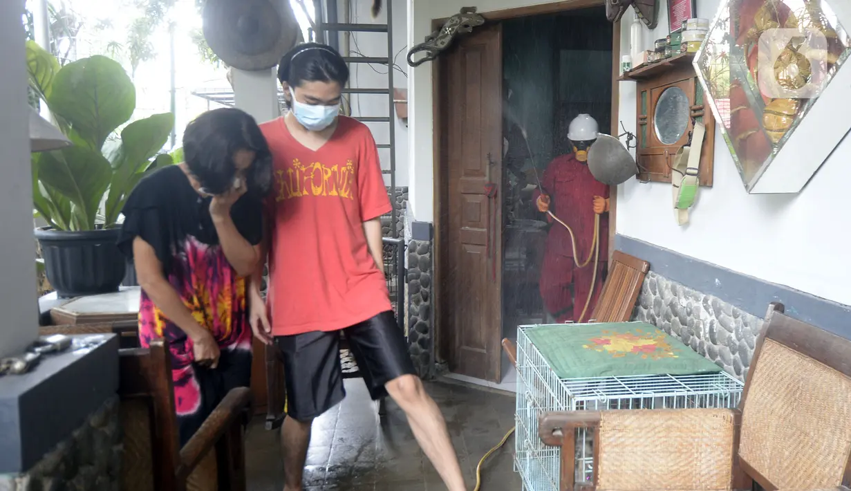 Warga menjauh saat petugas menyemprotkan cairan disinfektan di Perumahan Bukit Nusa Indah, Tangerang Selatan, Banten, Kamis (26/3/2020). Penyemprotan dilakukan untuk mengantisipasi penyebaran virus corona COVID-19 serta menyosialisasikan imbauan agar warga tetap di rumah. (merdeka.com/Dwi Narwoko)