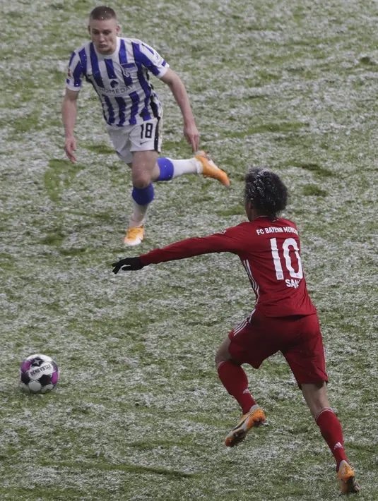 Penyerang Bayern Munchen, Leroy Sane berebut bola dengan gelandang Hertha Berlin, Santiago Ascacibar dalam ajang Bundesliga 2020/2021 pekan 20 di Olympiastadion, Sabtu (6/2/2021) dini hari WIB. Bayern Munchen menang dengan skor tipis 1-0 saat bertemu Hertha Berlin. (AP Photo/Michael Sohn, pool)