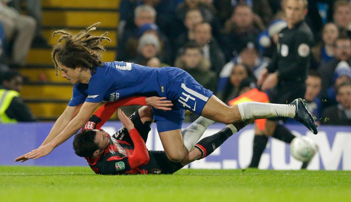 Pemain Chelsea, Ethan Ampadu dan pemain Bournemouth, Adam Smith terjatuh saat berebut bola pada laga perempat final, di Stadion Stamford Bridge, Kamis (21/12). Morata menjadi penentu kemenangan Chelsea atas AFC Bournemouth 2-1. (AP/Alastair Grant)