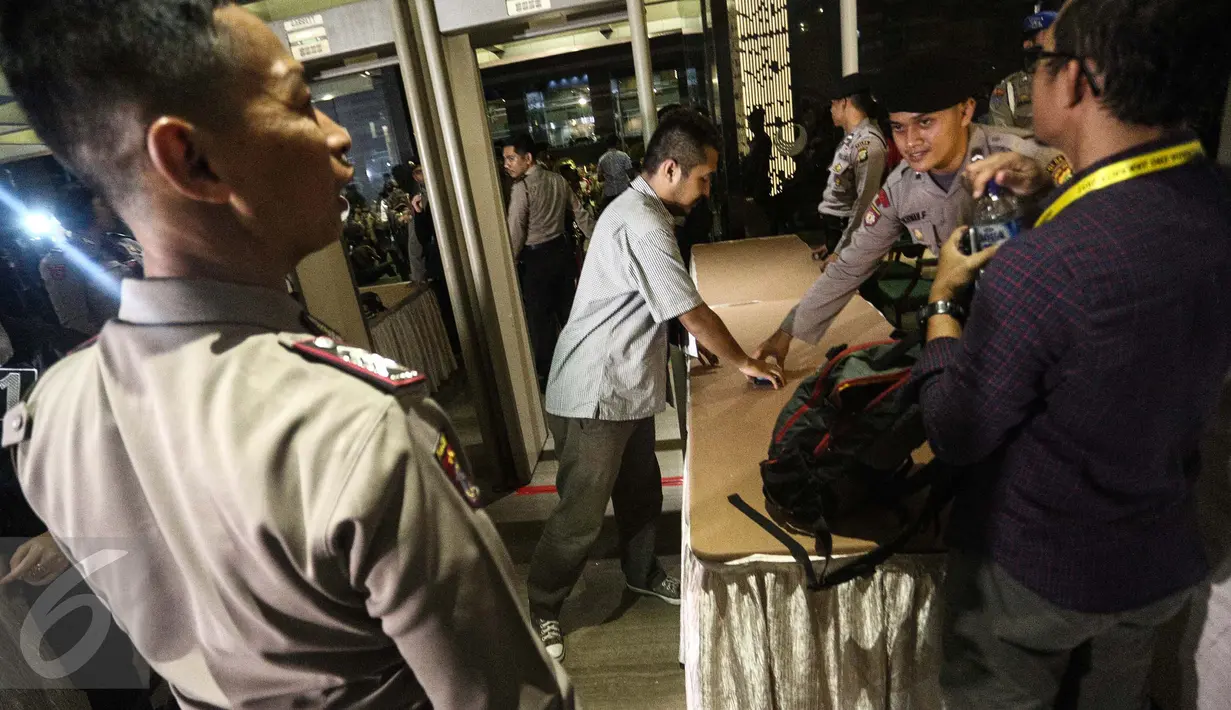 Petugas kepolisian mengecek tamu undangan saat menghadiri Debat terbuka pertama Cagub-Cawagub DKI Jakarta, Jumat (13/1). Debat cagub-cawagub DKI Jakarta 2017 dihelat malam ini di sepuluh stasiun TV nasional. (Liputan6.com/Faizal Fanani)