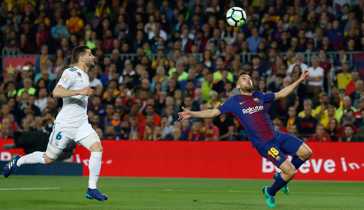 Pemain Barcelona, Jordi Alba mengontrol bola dibayangi pemian Real Madrid, Nacho pada pertandingan La Liga Spanyol di Stadion Camp Nou, Minggu (6/5). Real Madrid yang bermain dengan 11 pemain gagal mengalahkan 10 pemain Barcelona (AP/Manu Fernandez)