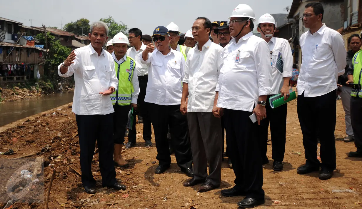 Kepala Balai Besar Wilayah Ciliwung-Cisadane, Teuku Iskandar (kiri) memberikan keterangan kepada Menteri PUPR, Basuki Hadimoeljono saat meninjau proyek normalisasi kali Ciliwung di Kampung Pulo, Jakarta, Senin (12/10). (Liputan6.com/Helmi Fithriansyah)