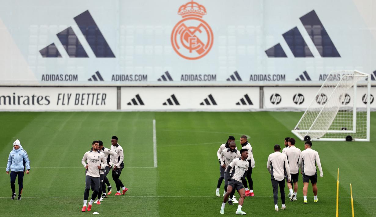 Para pemain Real Madrid melakukan pemanasan saat berlatih menjelang pertandingan babak 16 besar Liga Champions 2024/2025 melawan Atletico Madrid di Real Madrid Sports City, Valdebebas, Spanyol, Senin (03/03/2025) waktu setempat. (AFP/Thomas Coex)