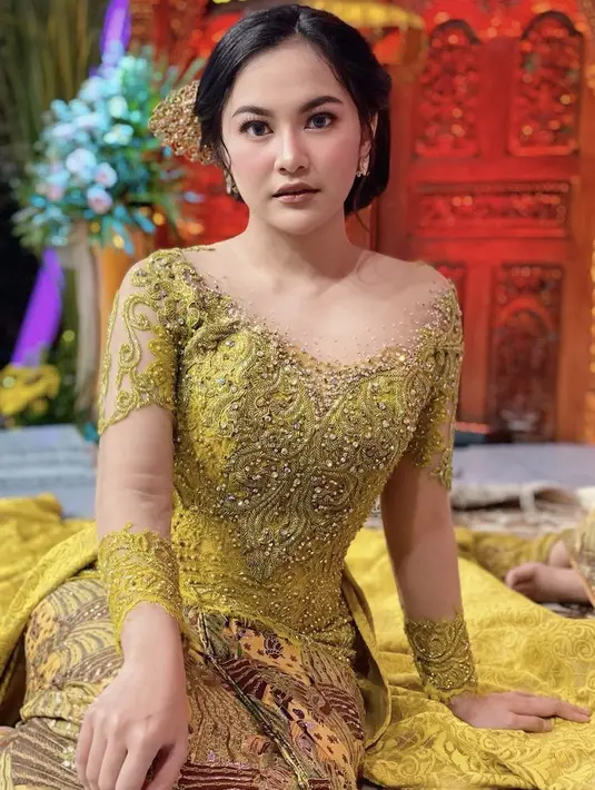 Penyanyi yang dikenal lewat lagu "Melawan Restu" yang viral di TikTok ini anggun mengenakan kebaya berpayet model sabrina warna kuning dengan bawahan kain lilit ikat bercorak batik. Sanggun minimalis dengan aksesori pun melengkapi penampilannya. (@mahaliniraharja)