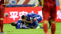 Demba Ba (kiri) menangis memegang kakinya yang terkena  tendangan pemain lawan pada laga China Super League (17/7/2016). (AFP/STR/China OUT)