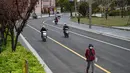 Seorang pria berjalan di jalan yang tenang di distrik Yangpu, di Shanghai (28/3/2022). Shanghai  lockdown setiap setengah kota secara bergiliran untuk tes Covid-19 massal mulai Senin (28/3/2022) di tengah lonjakan infeksi. (AFP/Hector Retamal)