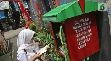 Seorang pelajar membaca buku di Kampung Literasi RW 08, Jatipulo, Palmerah, Jakarta Barat, Kamis (30/1/2020). Kampung Literasi ini memiliki 5 kotak berisi beragam buku yang ada di sejumlah titik, berbekal konsep kejujuran disebar di sepanjang kampung. (Liputan6.com/Herman Zakharia)