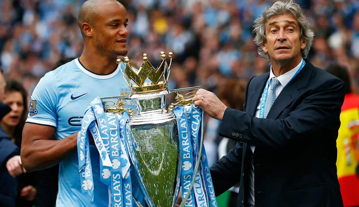 Kapten Manchester City, Vincent Kompany (kiri) bersama Manuel Pellegrini membawa trofi Liga Primer Inggris di Stadion Etihad, Manchester (11/5/2014). (REUTERS/Darren Staples)