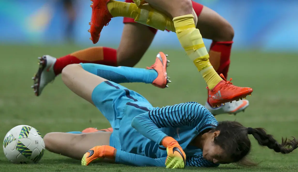 Kiper Lina Zhao dari China (bawah) melakukan penyelamatan saat laga melawan Swedia di Grup E Olimpide Rio 2016 di Stadion Mane Garrincha, Brasil pada 9 Agustus 2016. (REUTERS/ Ueslei Marcelino)