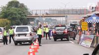 Petugas gabungan mengarahkan pengendara mobil untuk putar balik saat akan memasuki wilayah Jakarta di Gerbang Tol Cikupa, Tangerang, Rabu (27/5/2020). Kendaraan yang menuju Jakarta wajib menunjukkan Surat Izin Keluar atau Masuk (SIKM) untuk menekan penyebaran Covid-19. (Liputan6.com/Angga Yuniar)