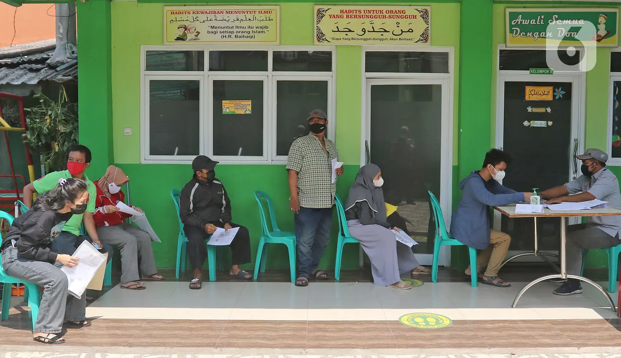 Warga menunggu giliran untuk mengambil uang bantuan sosial tunai (BST) dari Kemensos di kawasan Kelurahan Kembangan, Meruya, Jakarta Barat, Minggu (25/07/2021). Penyaluran BST tersebut diperkirakan akan rampung pada 7 Agustus 2021 mendatang. (Liputan6.com/Herman Zakharia)