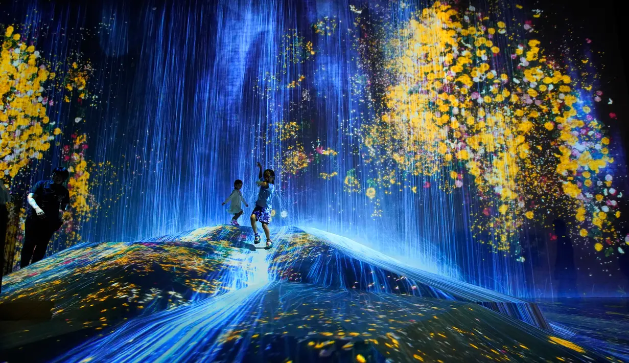 Anak-anak bermain di instalasi digital yang menampilkan proyeksi air terjun dan bunga di Museum Seni Digital Mori Building, Tokyo, 21 Juni 2018. Museum ini memberikan pengalaman spektakuler menuju negeri ajaib di masa depan. (AP/Shuji Kajiyama)