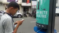 Salah seorang warga memanfaatkan charging station di Jalan Sudirman. Foto: (Huyugo Simbolon/Liputan6.com)