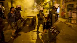 Polisi anti huru hara menahan seorang pemuda dalam bentrokan di pusat kota Athena, Yunani, (6/7/2015). Yunani Saat ini berstatus negara bangkrut, karena tidak bisa membayar utang-utangnya. (REUTERS/Marko Djurica)