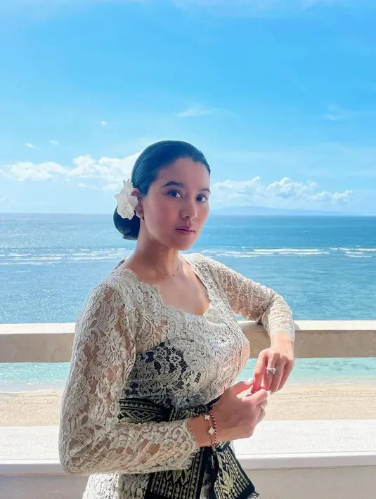 Marcella tampil dengan riasan natural dengan gaya rambut sanggul updo dihiasi bunga putih yang disematkan di sanggulnya. [@marcella.zalianty]