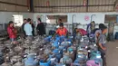 Pekerja Palestina mengisi tabung gas di stasiun pengisian resmi di kamp pengungsi Nuseirat, di bagian tengah Jalur Gaza, pada Senin 10 November 2025. Meski dalam jumlah terbatas, pasokan bahan bakar gas untuk memasak mulai didistribusikan ke warga Gaza. (Eyad Baba/AFP)