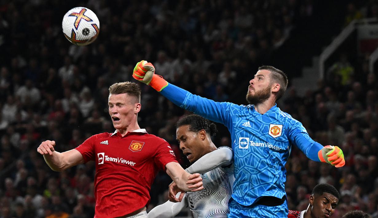 <p>Kiper MU, David de Gea (kanan), berhasil menghalau bola di udara dari pemain Liverpool, Virgil Van Dijk dalam pertandingan lanjutan Liga Inggris 2022/2023 yang berlangsung di Old Trafford, Senin (22/8/2022). (AFP/Paul Ellis)</p>
