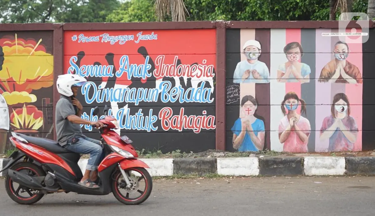 Pengguna jalan melintas dekat mural bergambar simbol orang berdoa menggunakan masker di kawasan Juanda, Kota Depok, Jumat (26/6/2020). Mural yang dibuat warga itu bertujuan memberi edukasi untuk menggunakan masker sebagai salah satu pencegahan dan penyebaran COVID-19 (Liputan6.com/Immanuel Antonius)