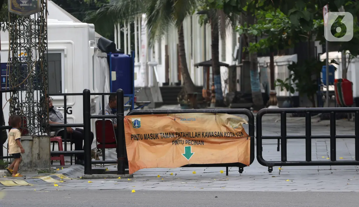 Petugas berjaga di sekitaran Jalan Kali Besar Barat kawasan Kota Tua, Jakarta, Minggu (19/9/2021). Meski Jakarta masih dalam masa PPKM level 3, kawasan ini mulai ramai dikunjungi warga untuk berwisata atau sekedar berfoto. (Liputan6.com/Helmi Fithriansyah)