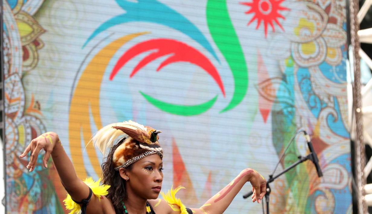 Seorang penari mengenakan mahkota burung Cendrawasih yang merupakan maskot Asian Games 18th Jakarta-Palembang saat peluncura logo di Senayan, Jakarta, Sabtu (27/12/2015). (Bola.com/Nicklas Hanoatubun)