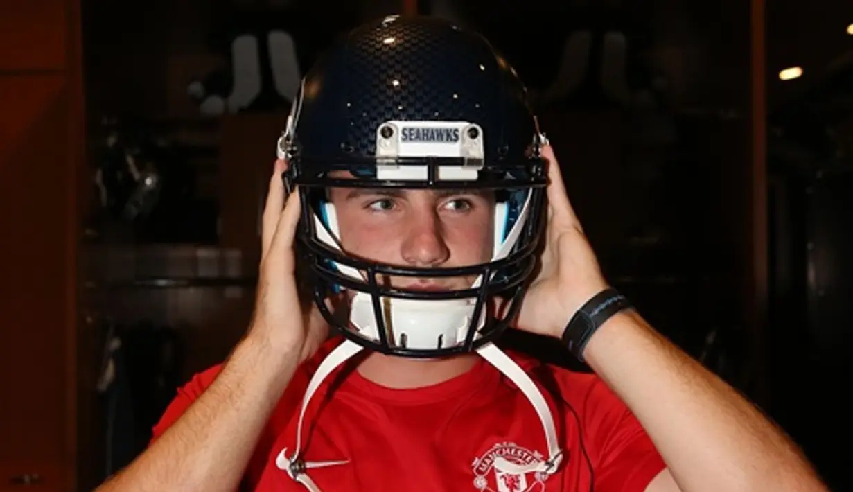 Luke Shaw mencoba perlengkapan American Football. (Manutd.com)