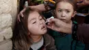 Petugas memberikan imunisasi polio di sepanjang jalan di Quetta, Pakistan, Senin (2/1). (REUTERS/Naseer Ahmed)