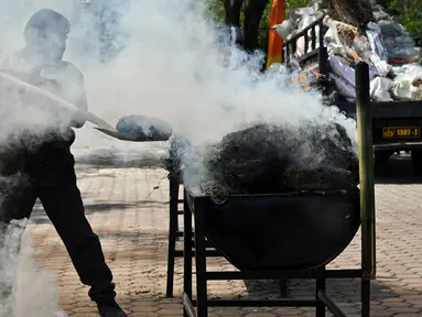 Polisi membakar barang bukti narkotika jenis ganja saat pemusnahan barang bukti di Polda Aceh, Banda Aceh, Aceh, Selasa (6/8/2024). (CHAIDEER MAHYUDDIN/AFP)