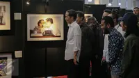 Presiden Joko Widodo melihat karya foto yang dipajang pada pameran foto jurnalistik Setahun Kerja Jokowi-JK di Museum Bank Mandiri, Jakarta, Jumat (18/12). Foto tersebut merupakan karya para anggota Pewarta Foto Indonesia (Liputan6.com/Faizal Fanani)