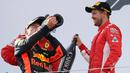 Pembalap Red Bull Max Verstappen meminum sampanye bersama dengan pembalap Ferrari, Sebastian Vettel dari Australia setelah berhasil memenangkan GP Austia di Red Bull Ring, Spielberg, Austria, (1/7). (AP Photo / Ronald Zak)