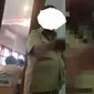 Dalam video itu, lelaki berbaju PNS itu asyik mengisap rokok, sementara rekannya sibuk melayani antrean warga. (Dok. istimewa))