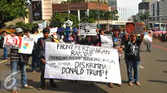 Sejumlah masa yang tergabung dalam front Perjuangan Rakyat membentangkan spanduk dan membawa poster saat melakukan aksi yang mengecam kebijakan Presiden Amerika Serikat Donald Trump di Jakarta, Minggu (5/2). (Liputan6.com/Angga Yuniar)