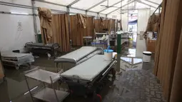 Imbasnya, layanan Instalasi Gawat Darurat (IGD) di tenda tersebut ditutup sementara. Tampak dalam foto, ranjang-ranjang kosong di dalam tenda darurat milik Rumah Sakit Nasser, yang berfungsi sebagai tempat penerimaan pasien rawat jalan dan departemen gawat darurat, setelah hujan lebat di Khan Yunis di Jalur Gaza selatan pada 26 Maret 2026. (Bashar Taleb/AFP)