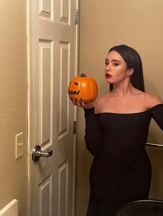 Beby Tsabina berpose sambil memegang mainan buah labu ciri khas Halloween. Beby tampil dengan aura yang menyeramkan. (Instagram/bebytsabina)