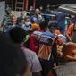 Petugas medis menerima jenazah di sebuah rumah sakit di Malang, Jawa Timur pada 2 Oktober 2022. Sedikitnya 174 orang tewas di stadion sepak bola Indonesia ketika ribuan penggemar tuan rumah yang marah menyerbu lapangan dan polisi menanggapi dengan gas air mata yang memicu desak-desakan, kata pihak berwenang pada 2 Oktober. (AFP/Juni Kriswanto)