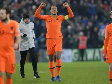 Bek Belanda, Virgil Van Dijk, merayakan keberhasilan lolos ke Piala Eropa 2020 usai melawan Irlandia Utara di Windsor Park, Belfast, Sabtu (16/11). Kedua negara bermain imbang 0-0. (AFP/Mark Marlow)