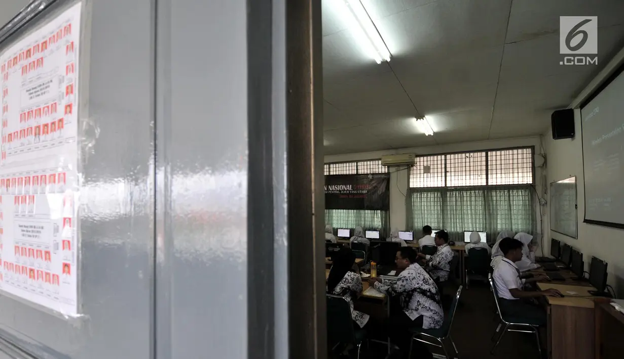 Guru mengawasi yang mengikuti Ujian Nasional Berbasis Komputer (UNBK) di Sekolah Menengah Kejuruan Negeri  (SMKN) 50 Jakarta, Senin (25/3). Sebanyak 69.407 siswa dari 578 SMK di DKI Jakarta mengikuti UNBK yang diselenggarakan pada 25-28 Maret 2019. (merdeka.com/Iqbal S. Nugroho)