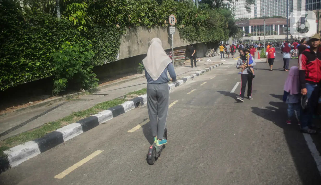 Warga mengendarai skuter listrik saat Car Free Day (CFD) di kawasan Bundaran HI, Jakarta, Minggu (17/11/2019). Dinas Perhubungan DKI Jakarta melarang penggunaan skuter listrik di kawasan CFD. (Liputan6.com/Faizal Fanani)