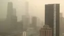 <p>Pemandangan kawasan pusat bisnis yang terpancar melalui jendela kaca saat terjadi badai debu di Beijing, Jumat, 10 Maret 2023. Upaya anti-penggurunan telah membantu mengurangi frekuensi dan intensitas badai yang sering mengubah udara di sekitarnya menjadi merah kekuningan yang dahsyat. (AP Photo/Borg Wong)</p>
