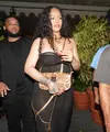 Rihanna tampak mengenakan black strappy dress semi transparan. Nuansa warna biru laut pada eye makeup dan beberapa aksesori emas yang dikenakannya membuat penampilannya ini semakin terlihat serasi.