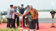 Presiden Joko Widodo (Jokowi) didampingi Ibu Negara Iriana Joko Widodo menekan tombol saat meresmikan empat ruas tol di Jawa Timur, Kamis (20/12). Peresmian ini menandakan Jakarta dengan Surabaya tersambung via Tol Trans-Jawa. (Liputan6.com/Angga Yuniar)