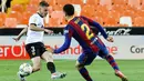 Bek Barcelona, Sergino Dest, berebut bola dengan pemain Valencia, Toni Lato, pada laga Liga Spanyol di Stadion Mestalla, Minggu (2/5/2021). Barcelona menang dengan skor 2-3. (AFP/Jose Jordan)