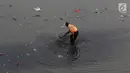 Petugas membersihkan sampah yang mengendap di Kanal Banjir Timur, Jakarta, Selasa (19/9). Diperkirakan sungai itu tercemar limbah sehingga airnya berwarna hitam pekat dan mengeluarkan bau tak sedap serta berbusa. (Liputan6.com/Immanuel Antonius)