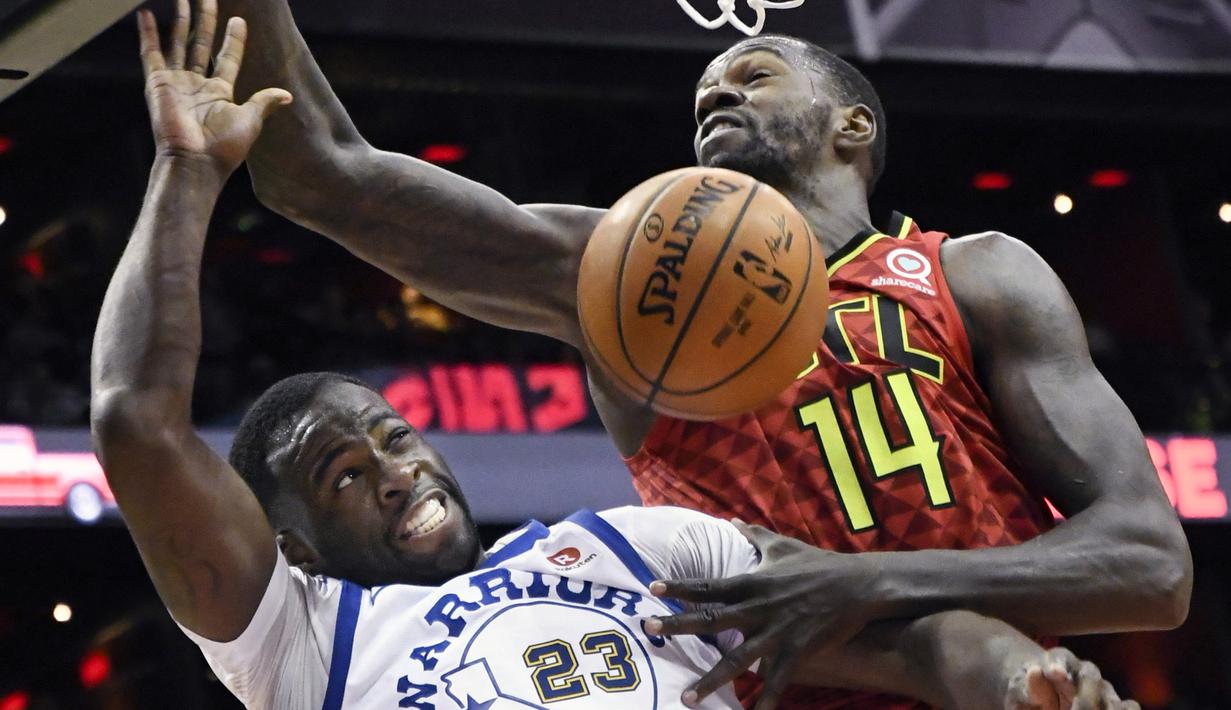 Pemain Warriors, Draymond Green #23 berusaha menghalau bola dari pemain Atlanta Hawks, Dewayne Dedmon #14 pada laga NBA basketball game  di Philips Arena, Atlanta, (2/3/2018). Warriors menang 114-109. (AP/John Amis)