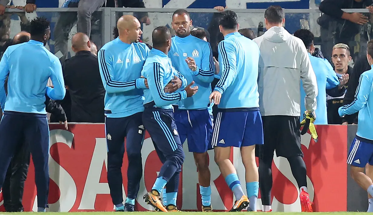 Bek Olympique Marseille, Patrice Evra berusaha ditenangkan oleh rekan-rekannya menjelang partai Liga Europa lawan Vitoria Guimaraes di Estadio D. Afonso Henriques, Jumat (3/11). Evra menendang kepala suporter karena kesal dihina. (AP/Luis Vieira)
