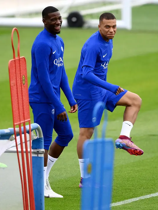 Pemain Paris Saint-Germain Nordi Mukele (kiri) dan Kylian Mbappe saat sesi latihan di tempat latihan klub di Saint-Germain-en-Laye, Prancis, Selasa (13/9/2022). Paris Saint-Germain (PSG) akan melawan Maccabi Haifa pada pertandingan sepak bola putaran pertama Grup H Liga Champions. (FRANCK FIFE/AFP)